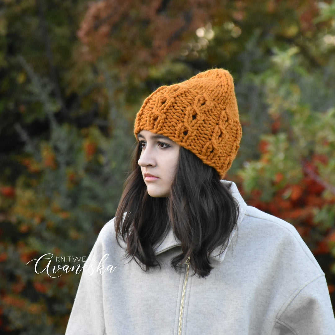 Woman wearing an orange knitted beanie in a forest setting