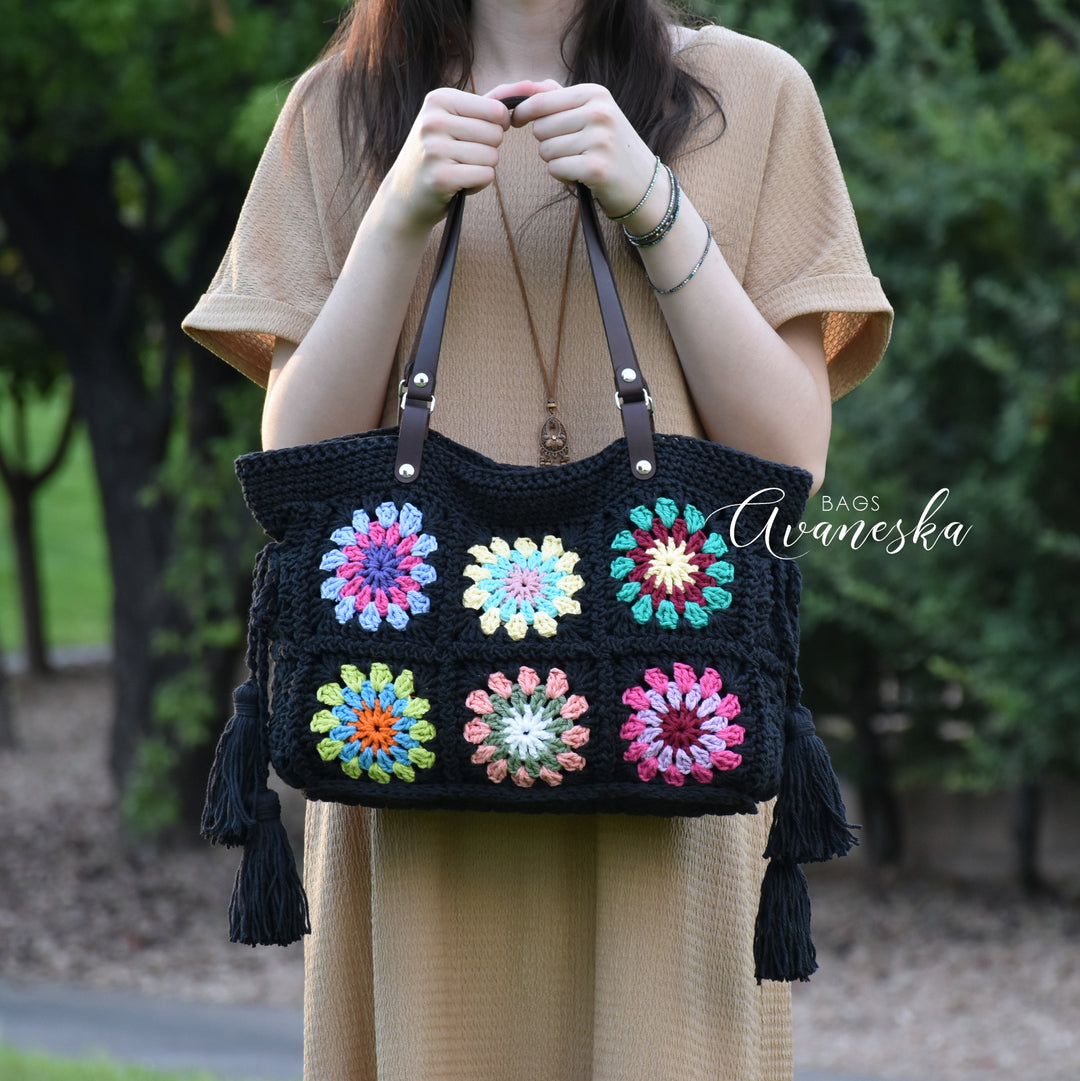 Handmade crochet granny square shoulder bag with vibrant colorful floral motifs.