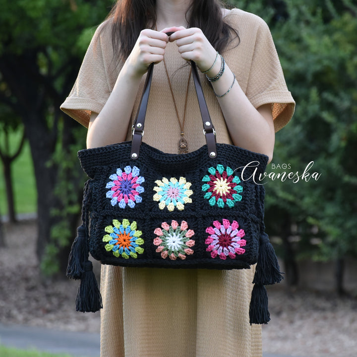 Handmade crochet granny square shoulder bag with vibrant colorful floral motifs.